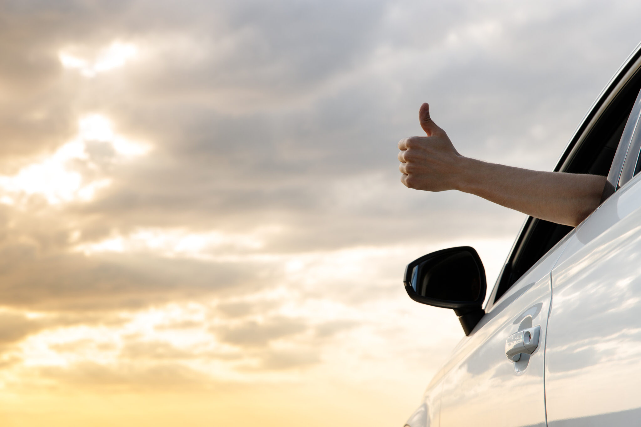 Man giving thumbs up out car window