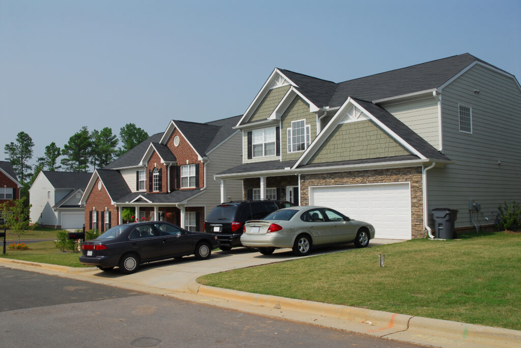 Residential house with three cars in the driveway