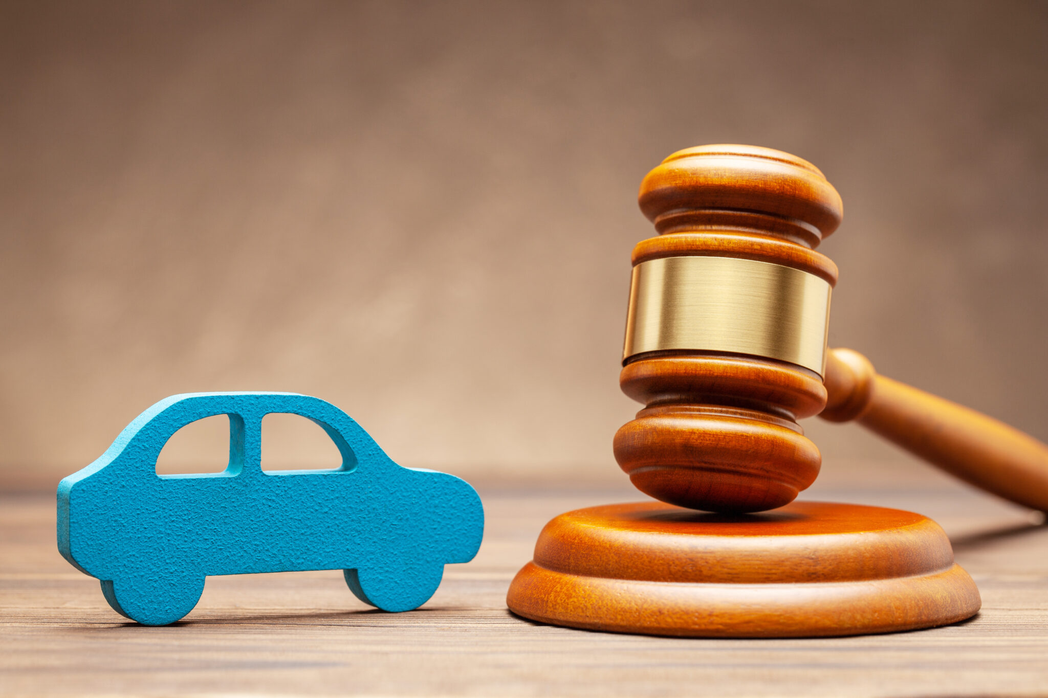 Car and judge gavel on brown background