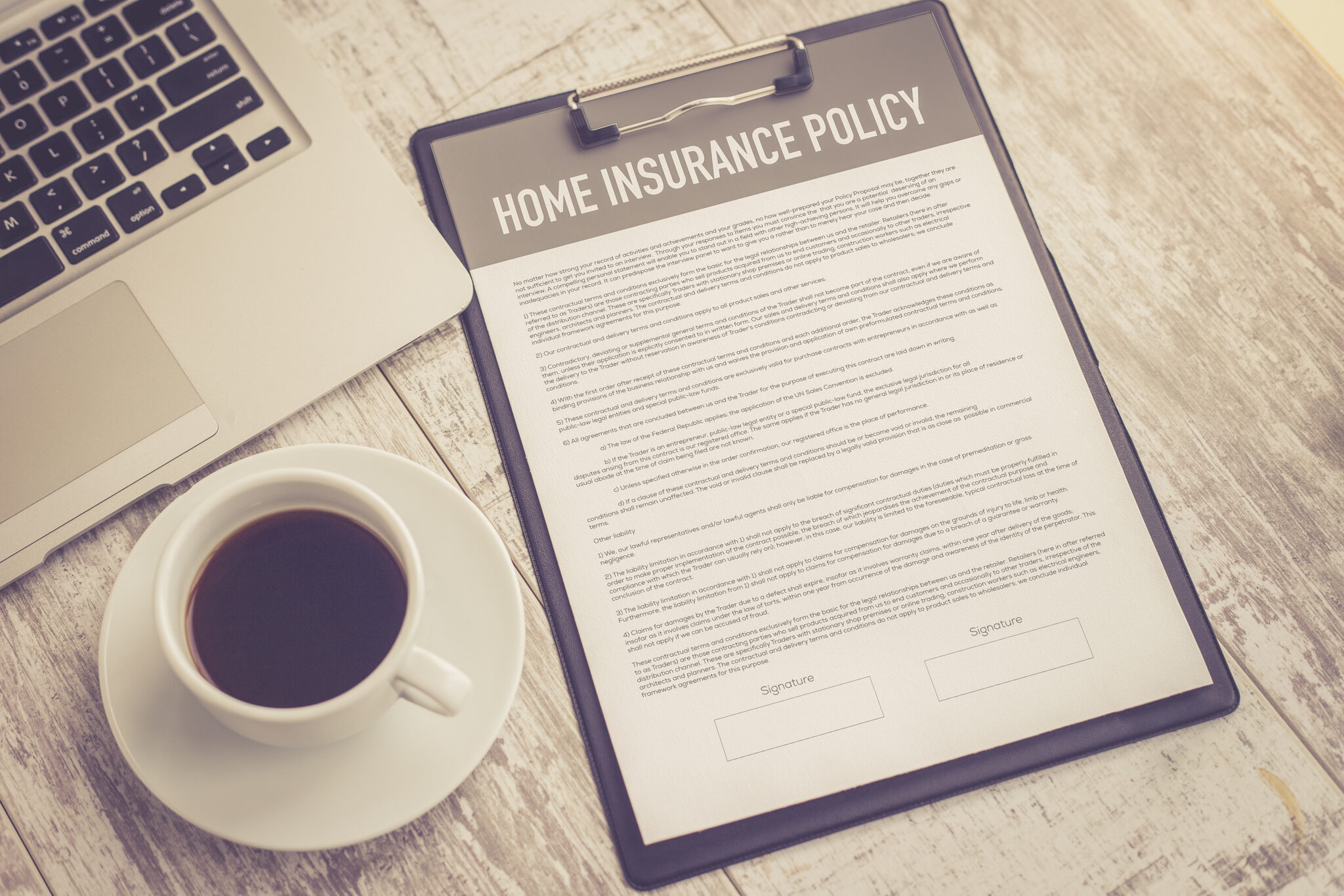 Home insurance policy form sitting next to laptop.