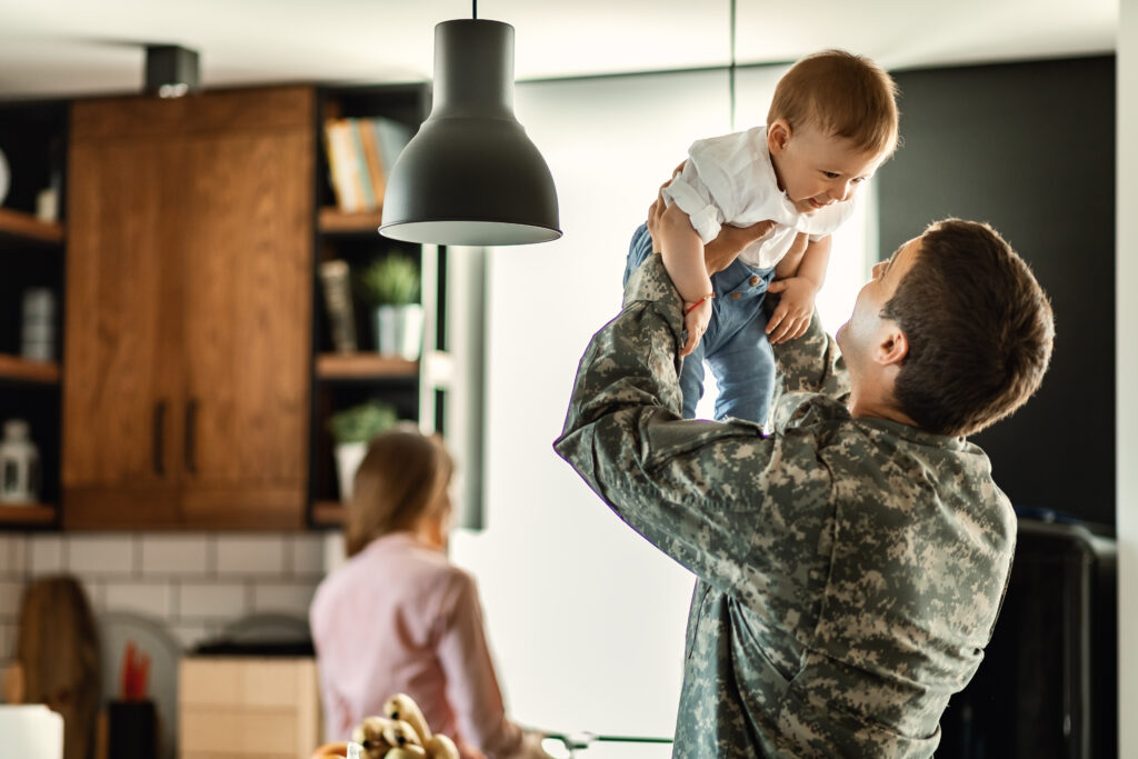 Military service member at home playing with his kid.