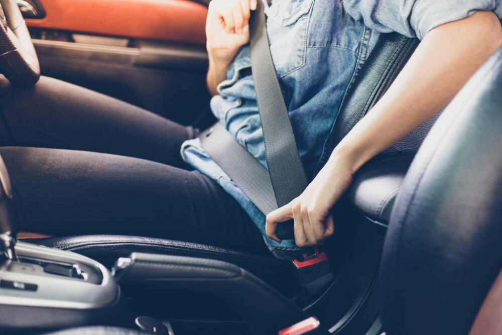 Driver fastening seat belt in car