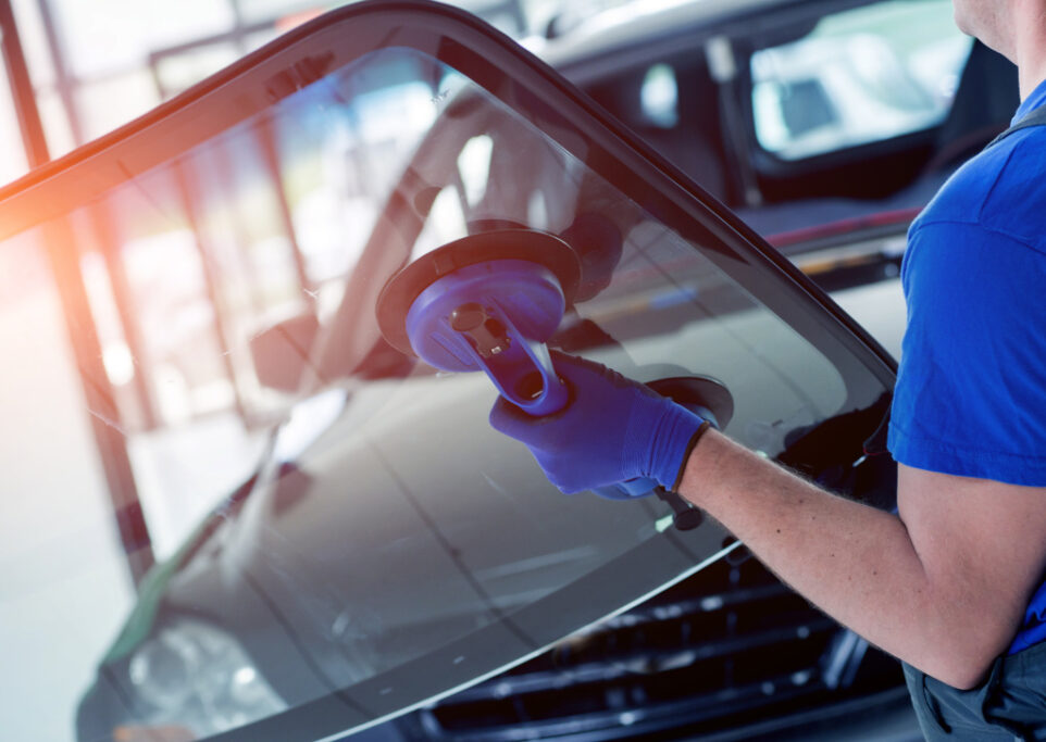 Auto repair workers replacing windshield